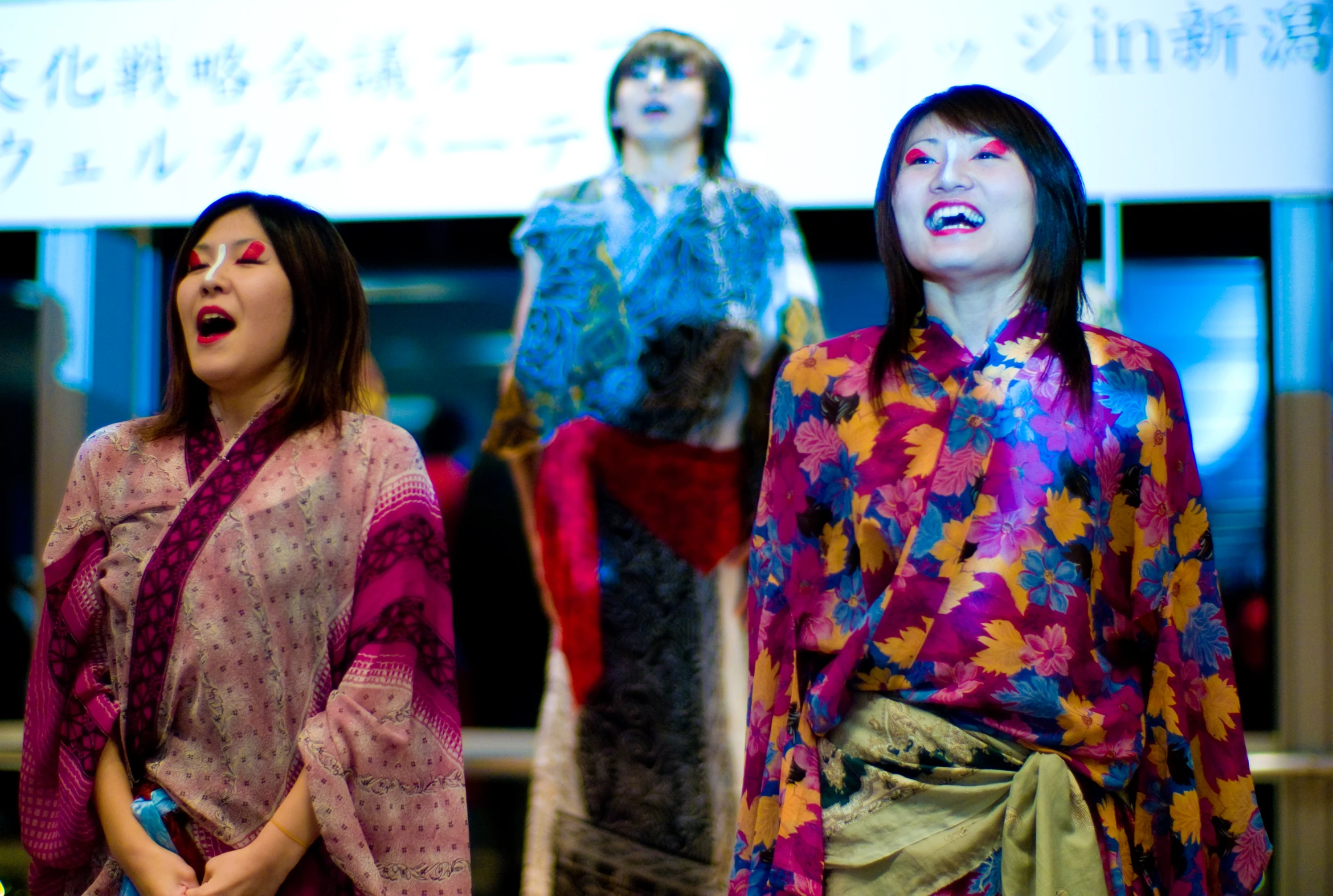 the women are singing while the woman stands in front of them