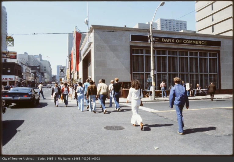 a group of people walking across a street in front of a bank of congress