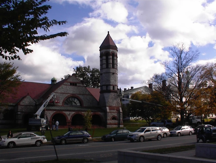 a building on a corner with a church and cars