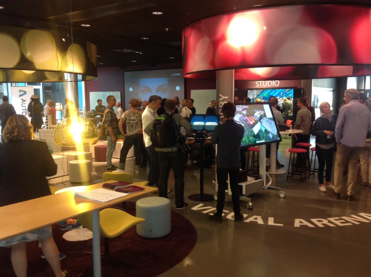 a crowd of people gathered around an exhibit with many computers on them