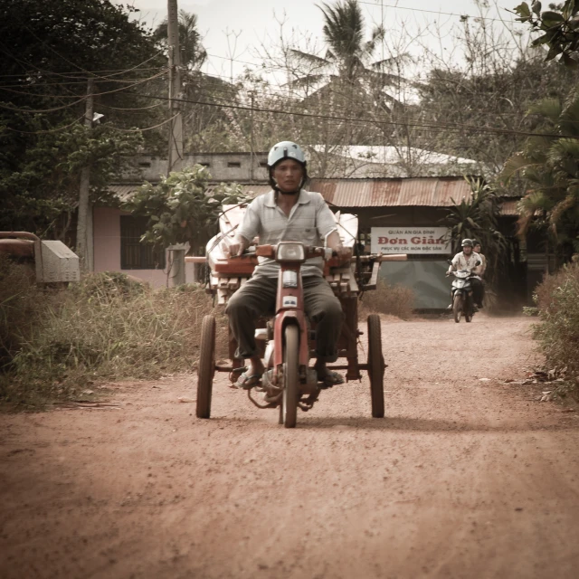 a man riding a motorcycle that is on top of a dirt road