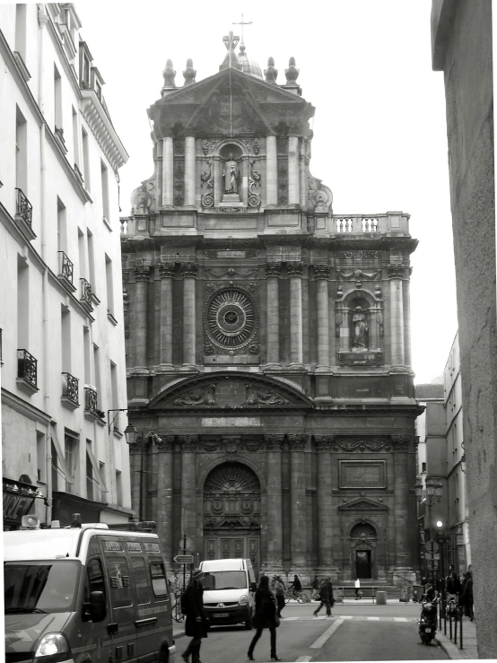 people cross a busy street in front of a church