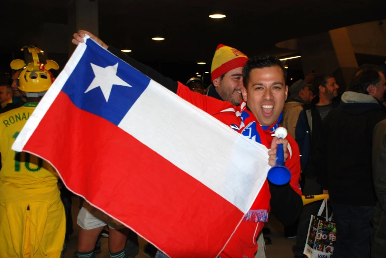 two men holding the national flag of chile