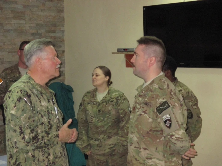 a group of people in military uniform talking to each other