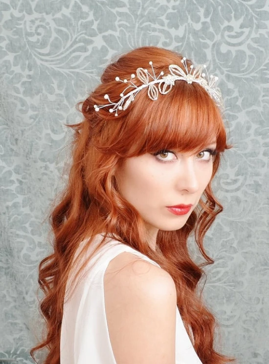 an attractive woman wearing a floral crown, in front of a wall