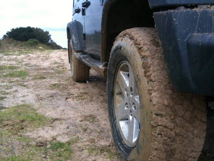 the tire of a truck in the dirt on a beach