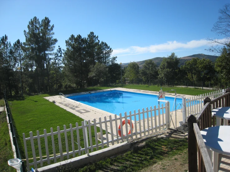 a fenced in pool with a small white fence around it