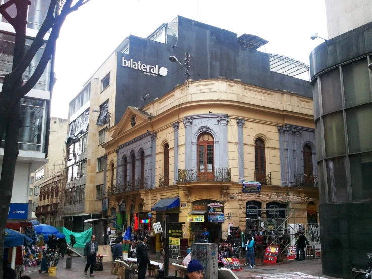 the shop on the corner is advertising italian and the store itself has an umbrella