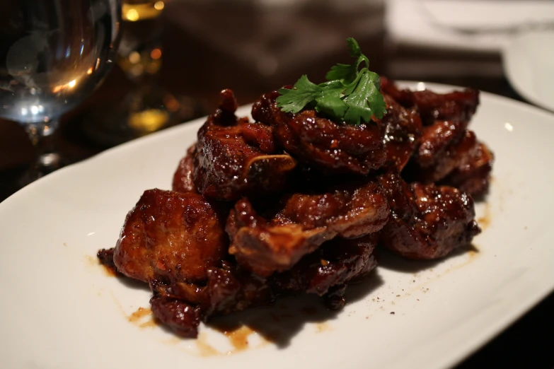 a plate filled with meat and garnished with herbs