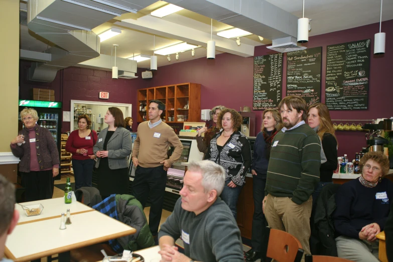 people gather together in a cafe to enjoy the wine