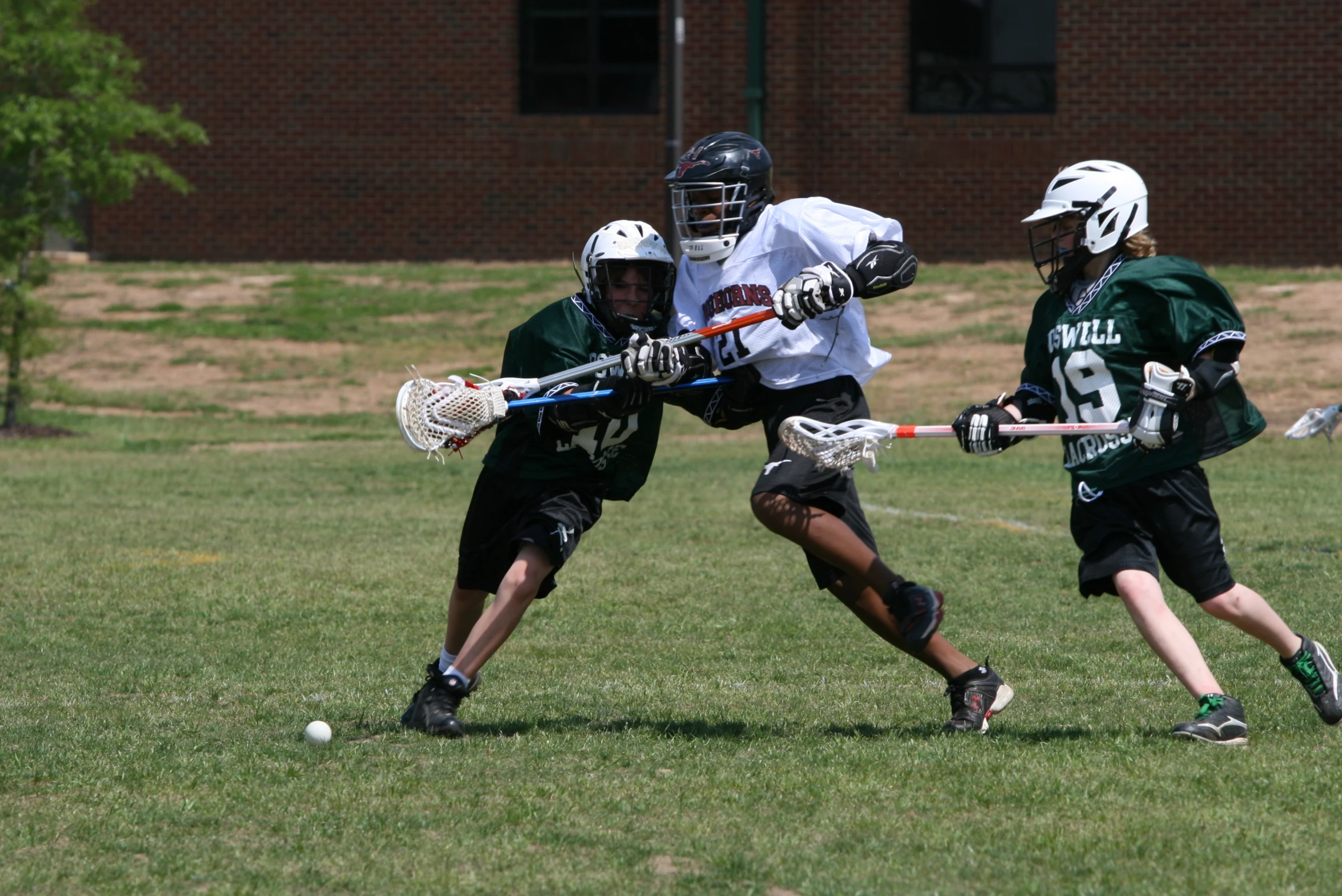 two youth lacrosse teams playing in a field