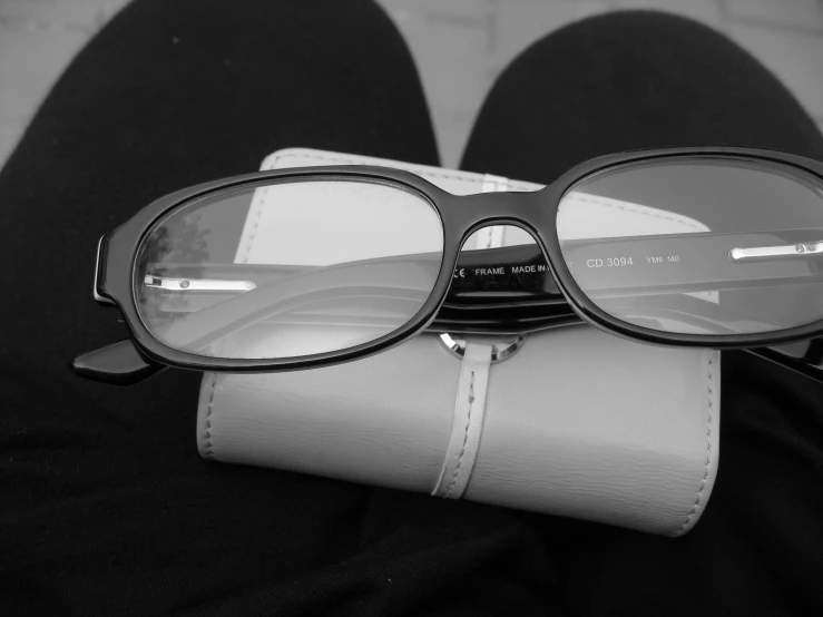 a person's legs are shown with black eyeglasses on their wallet