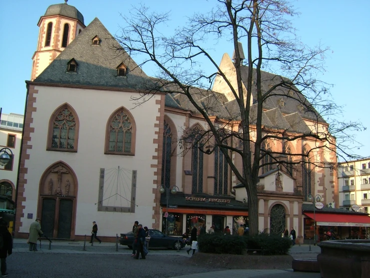 an old european building with people standing in the background