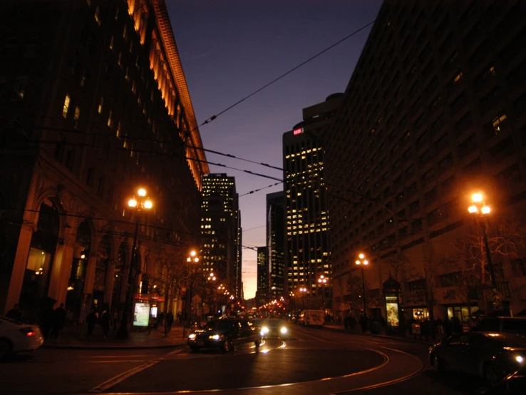 cars in the dark are lined up on a city street