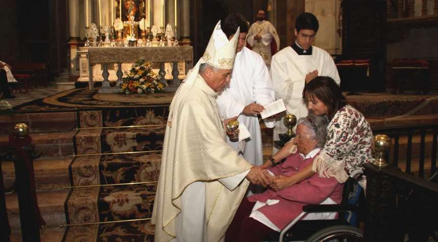 a church with several people wearing white robes and priesting a child