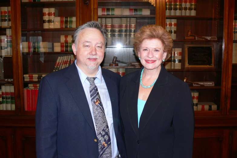 a woman and man in business attire posing for a po