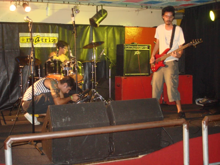 two men on stage with guitars and an amp