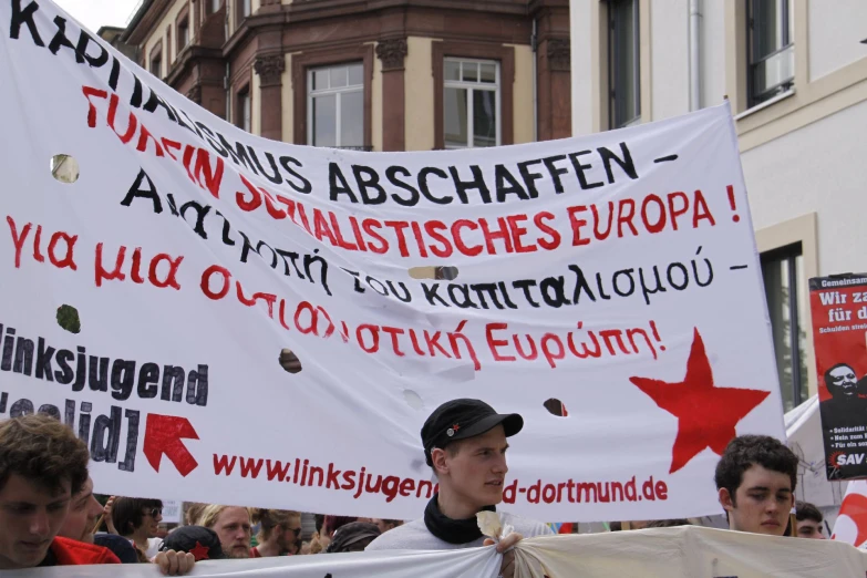 some people holding up large banners in front of a building