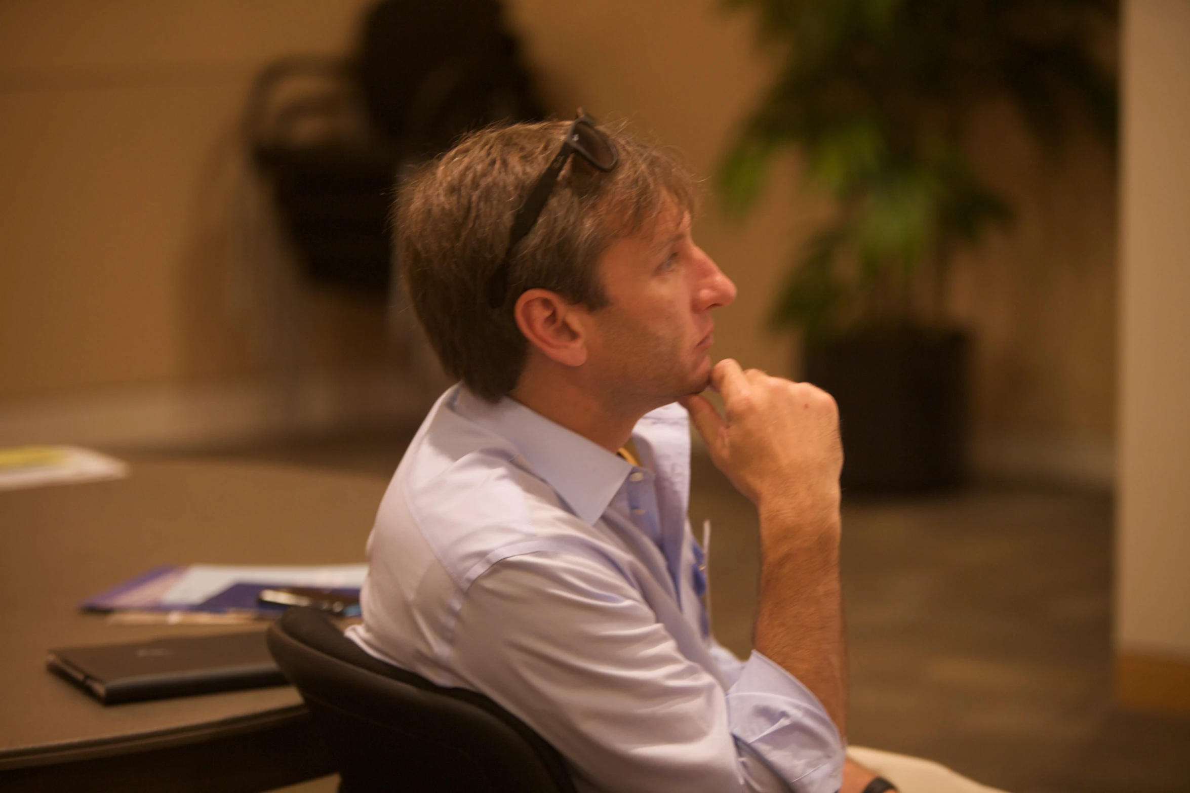 a man sitting at his desk with his hand under his chin