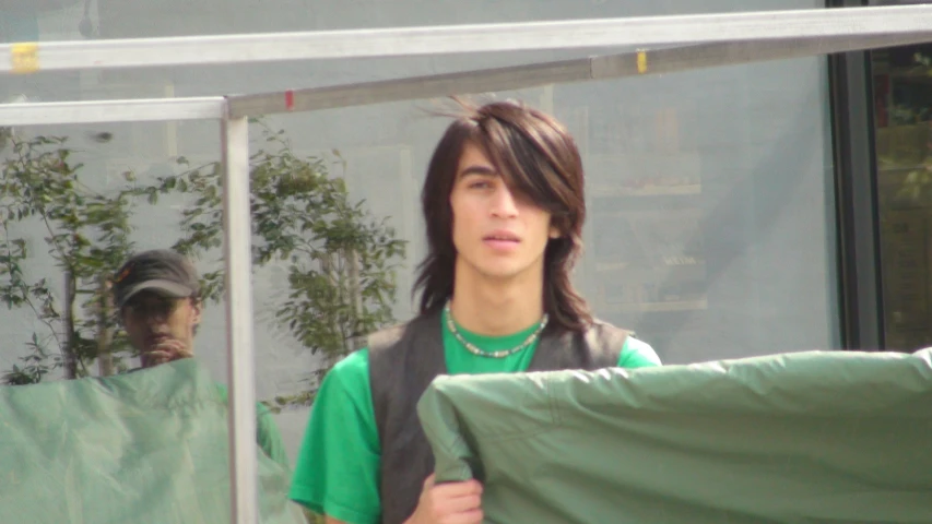 young male in green shirt carrying a banner