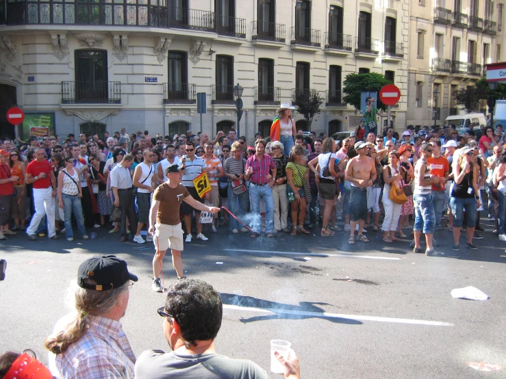 there are many people watching a man skateboarding on the street