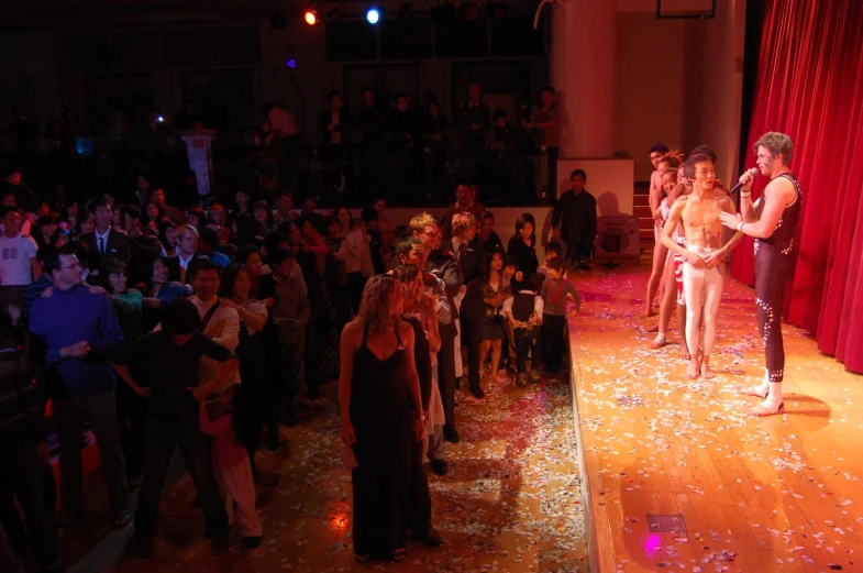 a male and female on stage in front of a large audience