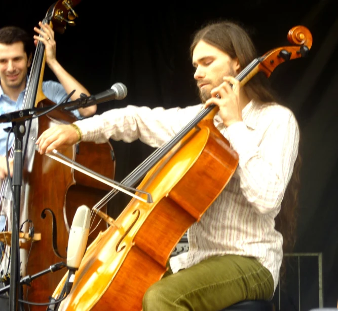 a man sitting down on the phone while playing a musical instrument