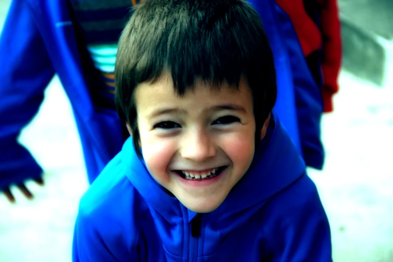 a boy smiling with an umbrella in the background