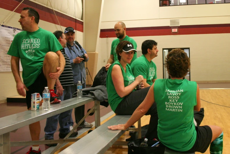 several people sitting and standing around a bench