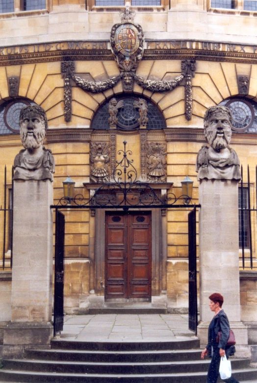 a woman walking up the stairs in front of a building