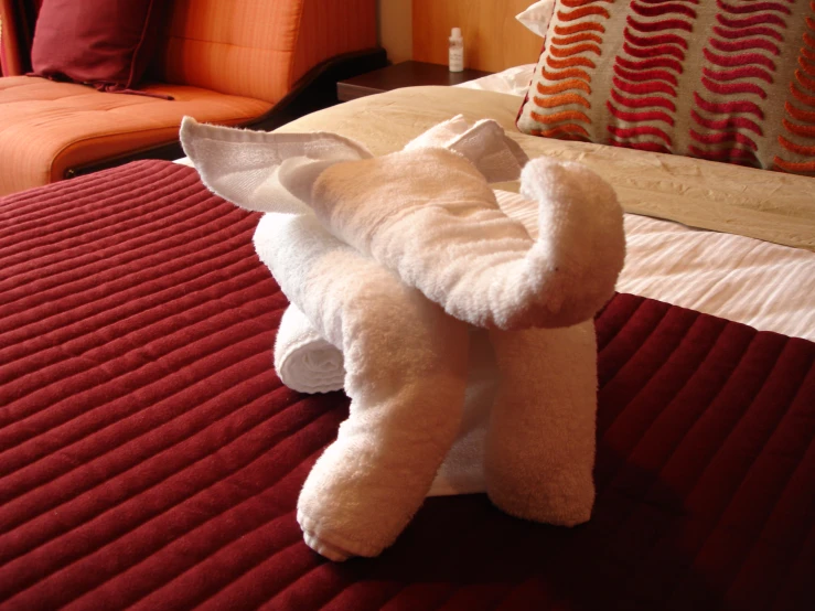 a white towel folded in the shape of an elephant on top of a bed