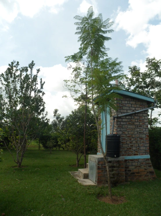 a brick cabin with a large chimney in a grassy area