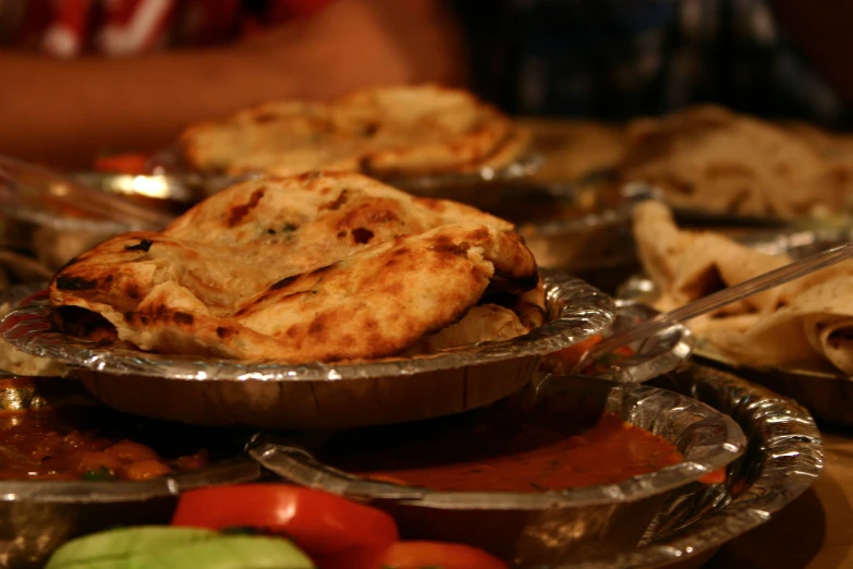 a table is topped with silver dishes filled with pies