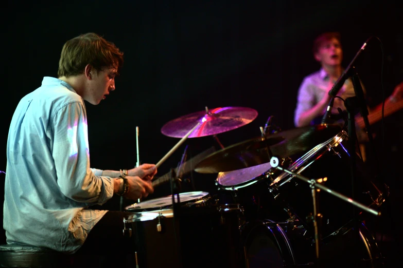 two men are playing drums together at night