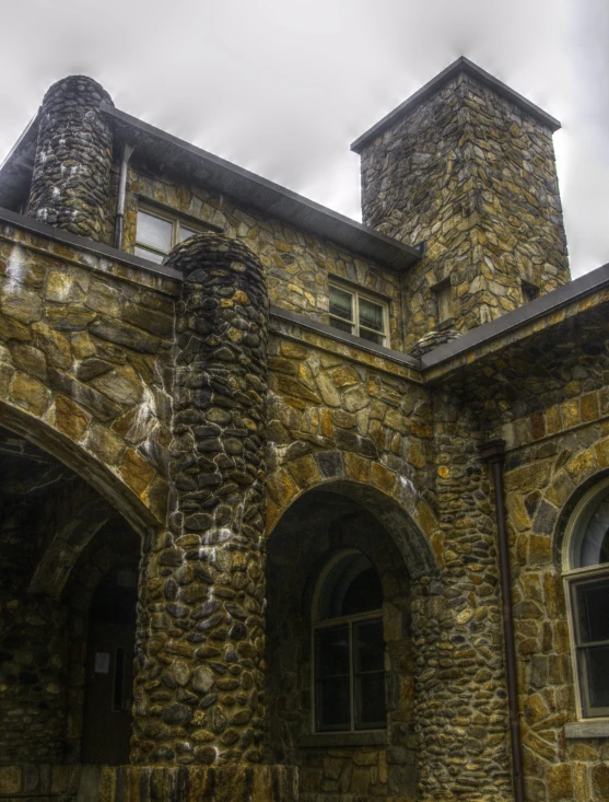 a stone castle with two towers that are surrounded by trees