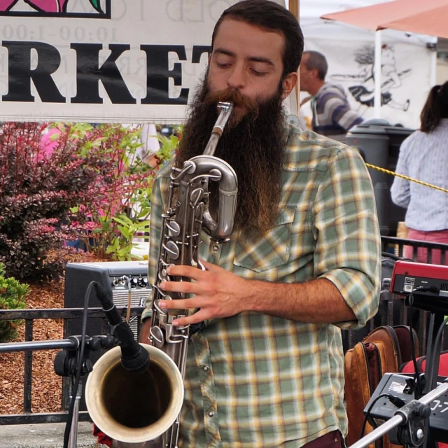 a man playing the trumpet on stage at a music festival