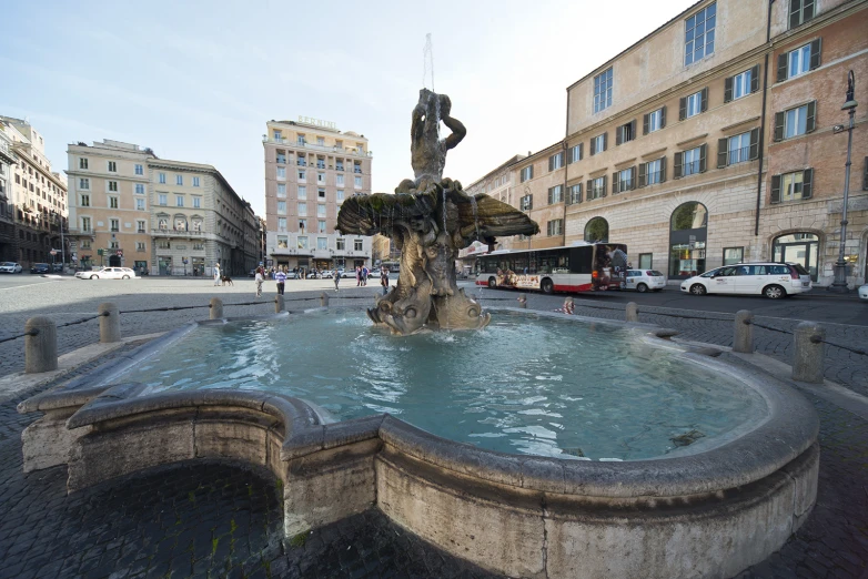 the fountain on the pavement is surrounded by water