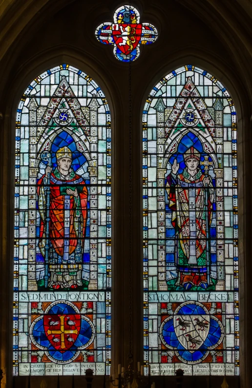 two stained glass windows that are on the side of a building