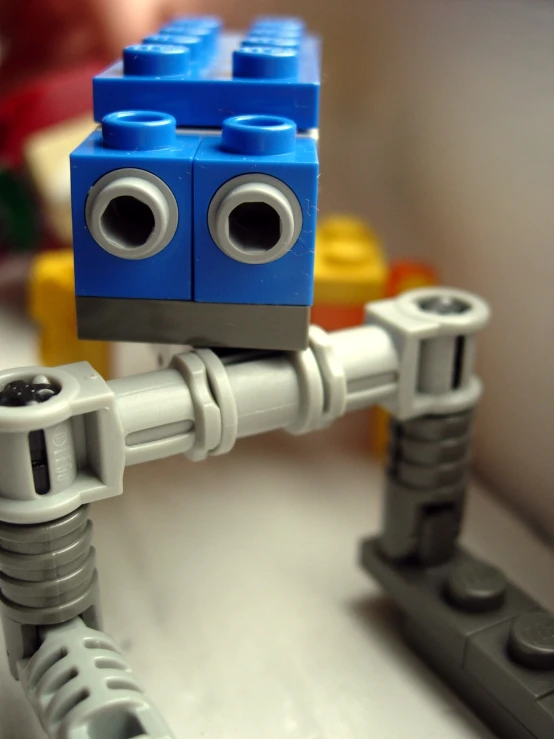 a blue and grey lego robot sitting on top of a sink