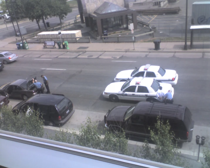 police cars in a parking lot near some grass and trees