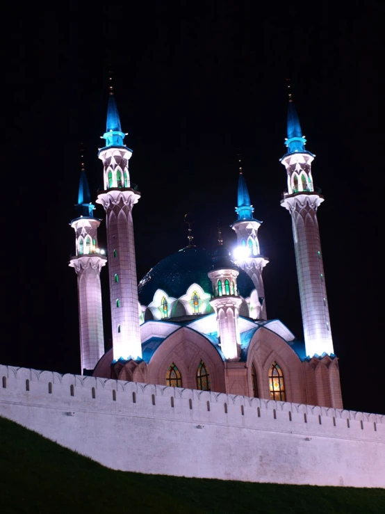 two large white buildings lit up at night