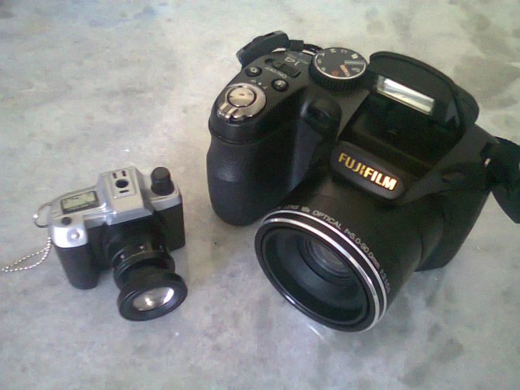 a black camera with flash attached and other equipment on the ground