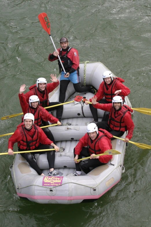 an inflatable raft with five people posing for a po