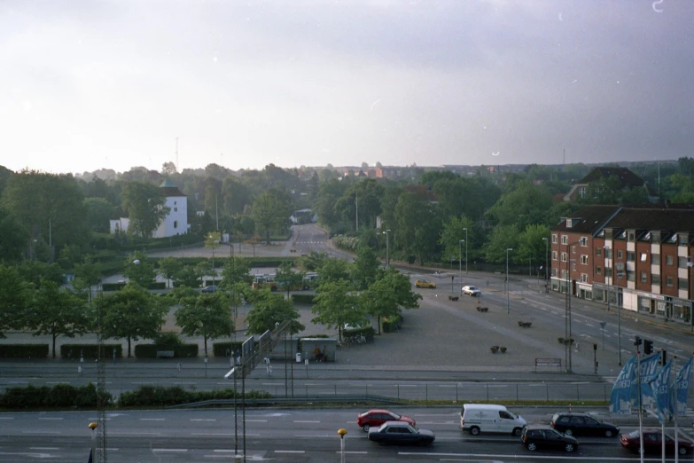 several cars parked along a city street near a park