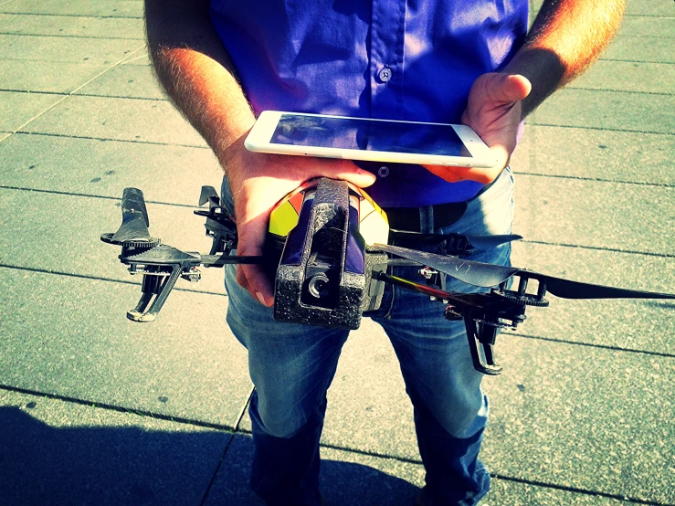 a man holding an electronic device with propellers attached to it