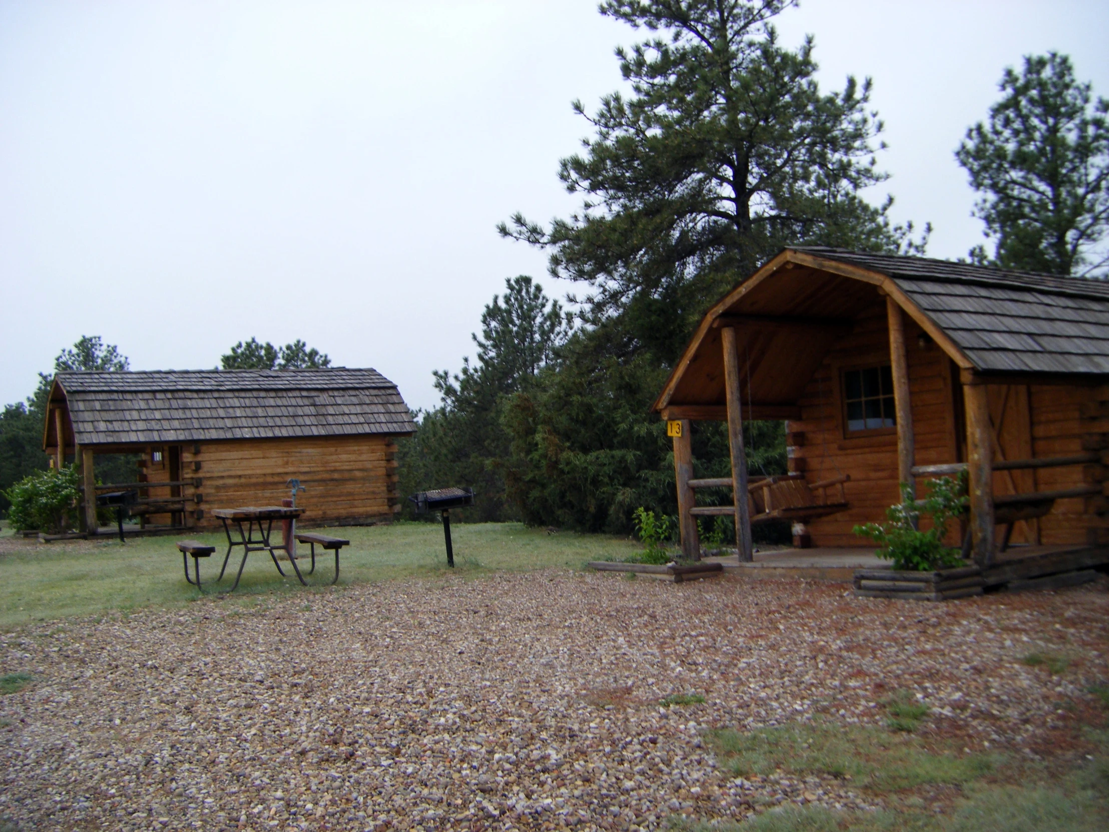 there are picnic benches next to two tiny cabins