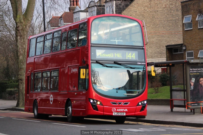 a red double decker bus driving down the street