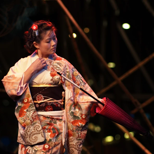 a women in oriental clothes holding an umbrella