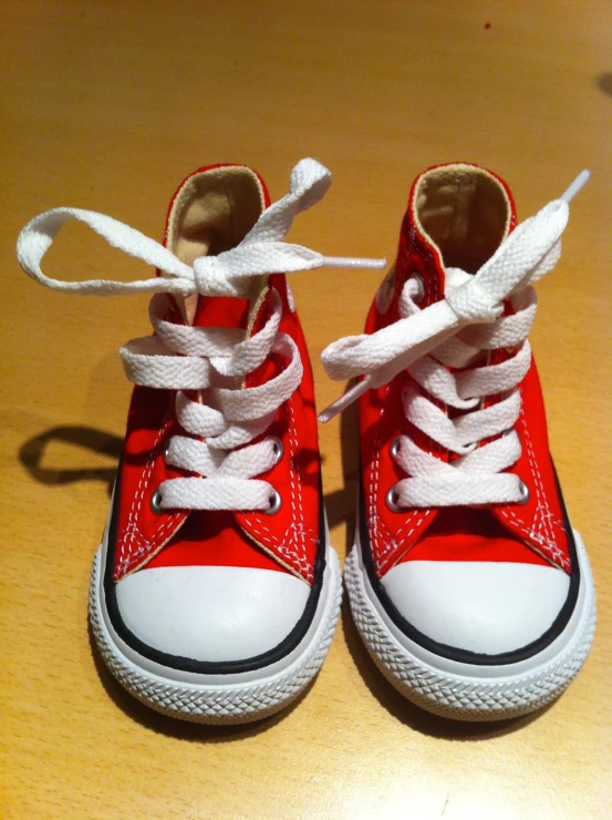 red and white converses lace up on the ground