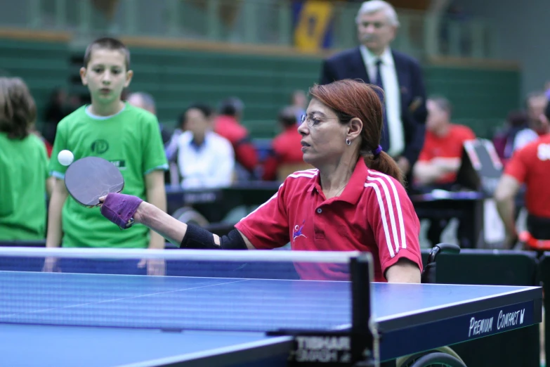 the woman is hitting the ping pong ball on the table